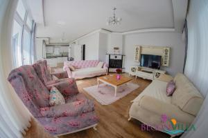 a living room with two couches and a tv at BegonVilla Fethiye-Göcek in Muğla