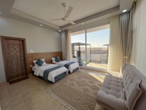 a bedroom with two beds and a large window at R61 Sunset Chalet in Muntarib
