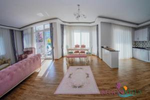 a living room with a pink couch and a table at BegonVilla Fethiye-Göcek in Muğla