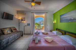 two beds in a room with a green wall at Seafront Spirit Suites in Zakynthos