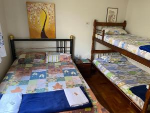 two twin beds in a room with a painting at Pousada Luar da Canastra in Piauí