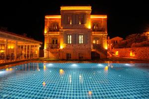 uma grande piscina em frente a um edifício à noite em Naz Su Cunda em Cunda