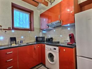 a kitchen with red cabinets and a washing machine at Studio de la Noblesse*Paris*Disneyland* 