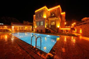 uma piscina em frente a um edifício à noite em Naz Su Cunda em Cunda