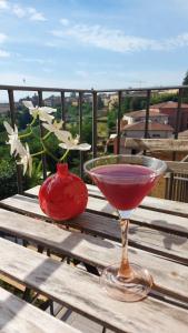 un drink in un bicchiere su un tavolo di legno con un vaso di Casa Baroncelli a Siena Altre 13 foto