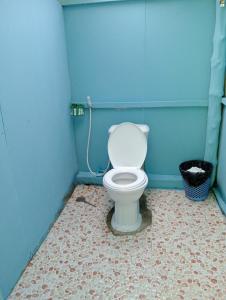a bathroom with a white toilet in a blue wall at White Pearl Beach in Koh Rong
