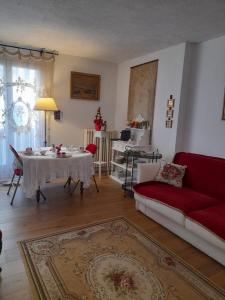 a living room with a table and a red couch at Chambre d'hôtes avec garage au bord de mer in Toulon