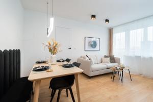 a living room with a table and a couch at Kairos Apartments - New York Premium- darmowy parking, ścisłe centrum, Spodek in Katowice