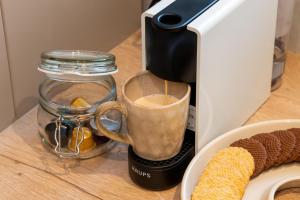 a coffee maker on a counter with a cup of coffee at Kairos Apartments - New York Premium- darmowy parking, ścisłe centrum, Spodek in Katowice