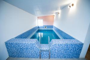 a swimming pool in a room with blue tiles at Hotel Zemo Aragvi in Gudauri