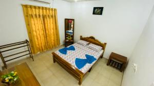 a bedroom with a bed with blue arrows on it at Thambapanni safari hostel in Moragaswewa