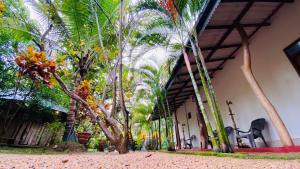 a building with palm trees on the side of it at Thambapanni safari hostel in Moragaswewa