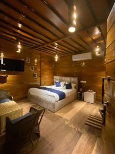 1 dormitorio con 1 cama grande en una habitación con paredes de madera en Lemonwood cottage, en North Lakhimpur