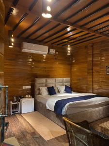 1 dormitorio con 1 cama grande y paredes de madera en Lemonwood cottage, en North Lakhimpur