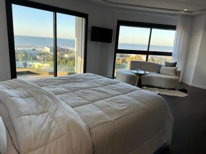 a bedroom with a large white bed and large windows at Luxury Villa Jack Beach Resort Ocean Oasis View Panoramic in Casablanca