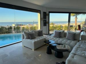 a living room with a white couch and a large window at Luxury Villa Jack Beach Resort Ocean Oasis View Panoramic in Casablanca