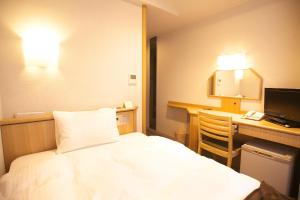 a hotel room with a bed and a desk at Yokote Plaza Hotel in Yokote