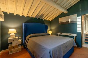 Relais La Martina في Pietraviva: غرفة نوم بسرير وكرسي ازرق