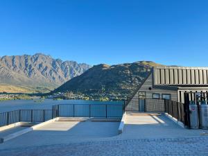 a building with a view of a lake and mountains at Stunning Lakeview Holiday House Queenstown in Frankton Wharf