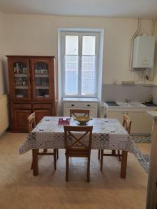 La cocina está equipada con mesa, sillas, mesa y mesa. en Maison d'hôtes du Faubourg Charrault Saint Maixent L'Ecole, en Saint-Martin-de-Saint-Maixent