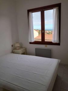 a bedroom with a large white bed and a window at 6CHK4 Villa 6 personnes dans résidence in Collioure
