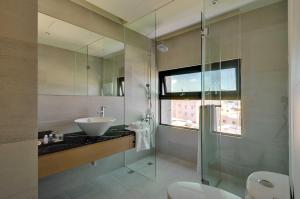 a bathroom with a sink and a glass shower at Mu Guang Zhi Ju Homestay in Magong
