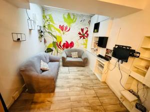 a living room with a couch and a television at Maison d'hôtes à 2 pas de Paris in Les Lilas