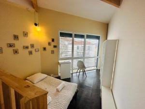 a small room with a bed and a refrigerator at Maison d'hôtes à 2 pas de Paris in Les Lilas