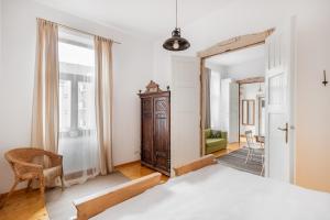 ein Schlafzimmer mit einem Bett, einem Stuhl und einem Spiegel in der Unterkunft Rustic Visual in Oradea