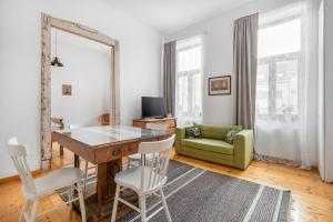 ein Wohnzimmer mit einem Tisch und einem grünen Sofa in der Unterkunft Rustic Visual in Oradea