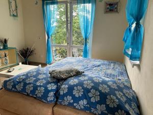 1 dormitorio con 1 cama con edredón azul y ventana en Chata se zahradou v Liberci, en Liberec