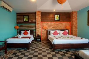 two beds in a room with blue walls at RESIDENCE 1960 in Siem Reap