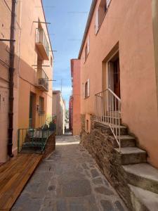 un callejón entre dos edificios con escaleras en un callejón en 6CONV20 charmante maison de village au cœur du faubourg en Collioure