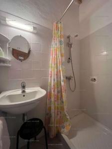 a bathroom with a shower curtain and a sink at 6CONV20 charmante maison de village au cœur du faubourg in Collioure