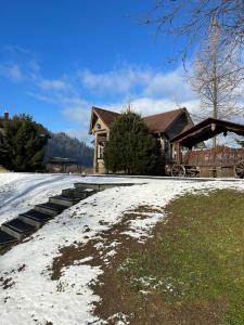 a house with snow on the ground in front of it at Bozhena in Mykulychyn