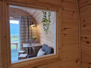 ein Fenster in einem Holzzimmer mit einem Tisch und einem Stuhl in der Unterkunft Gorse Gorgeous Glamping Hideaway in Dundonnell