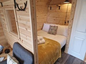 Gorse Gorgeous Glamping Hideaway في Dundonnell: غرفة بسرير في كابينة خشبية