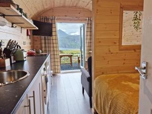 Gorse Gorgeous Glamping Hideaway في Dundonnell: مطبخ مع سرير ومغسلة في الغرفة