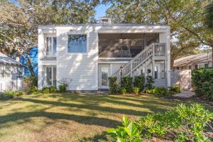a white house with a porch and a yard at After Dune Delight - 626 Beachview Drive in Saint Simons