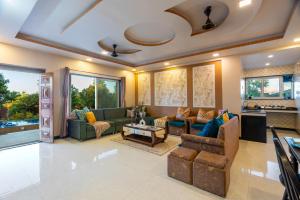 a living room with couches and a table at Malibu Villa by Hill Staytion in Panchgani