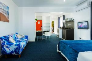 a hotel room with a bed and a couch at C-view Apartments in Flic-en-Flac