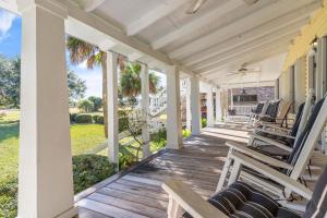 eine Veranda mit Schaukelstühlen auf einem Haus in der Unterkunft You are my Sunshine - 4213 Fifth Street in Saint Simons Island