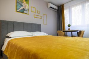 a bedroom with a large bed with a yellow blanket at Casa Rusu -Victoria-Self check in-24h in Reşiţa