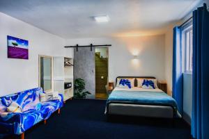 a bedroom with a bed and two couches at C-view Apartments in Flic-en-Flac