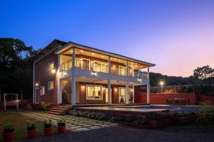 a house with a lit up facade at night at Malibu Villa by Hill Staytion in Panchgani