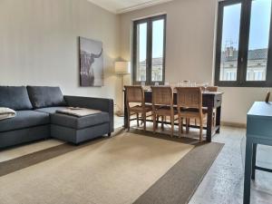 uma sala de estar com um sofá, uma mesa e cadeiras em Le Coté Cour - Fibre - Clim - Centre-ville em Albi