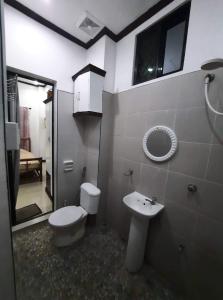 y baño con aseo, lavabo y espejo. en 1BR, 1BD condo Rentals, Toril, en Davao City