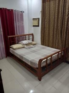 Cama de madera en habitación con cortinas en 1BR, 1BD condo Rentals, Toril, en Davao City