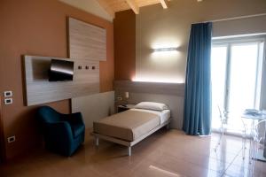 - une chambre avec un lit et une chaise bleue dans l'établissement CallMe Crema - Struttura in centro storico, à Crema