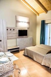a bedroom with a bed and a flat screen tv at CallMe Crema - Struttura in centro storico in Crema